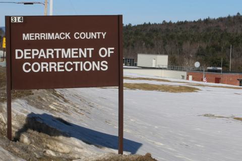 The sign for the Merrimack County Jail. There is snow surrounding the sign on a clear day.