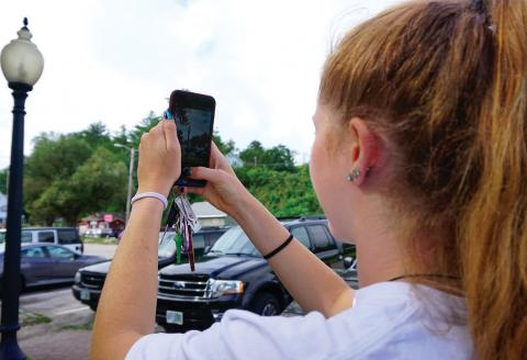 Hannah takes a picture of a light post with her phone