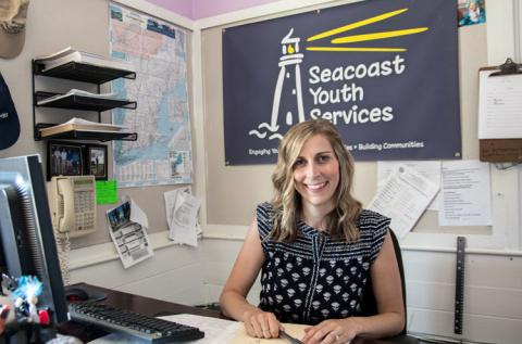 Former UNH cooperative Extension intern Stephanie Wright poses behind her desk at Seacoast Youth Services.