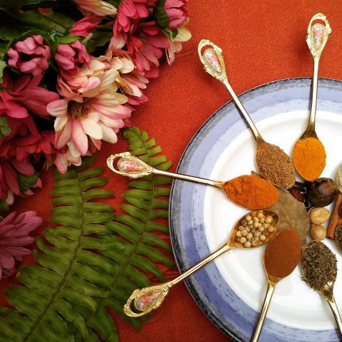 Spoons full of different spices and herbs on a plate