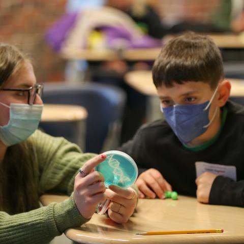 UNH student showing a child bacteria