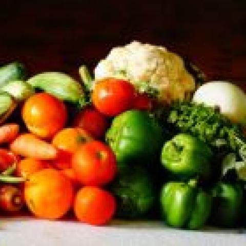 Fruits and Vegetable including peppers, tomatoes, carrots, on a table 