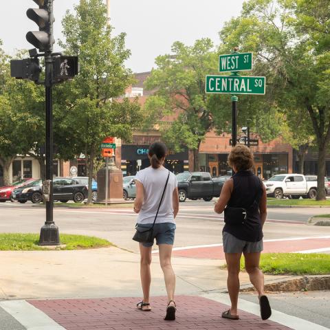 Two people walking in crosswalk downtown