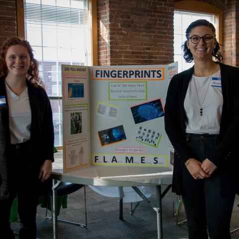 Three women standing in from of poster that says "fingerprints"