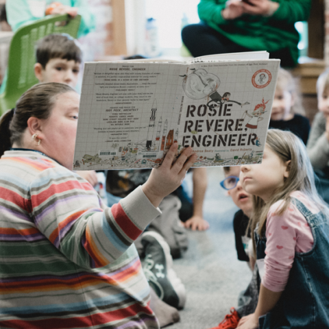 Volunteer reading book to children