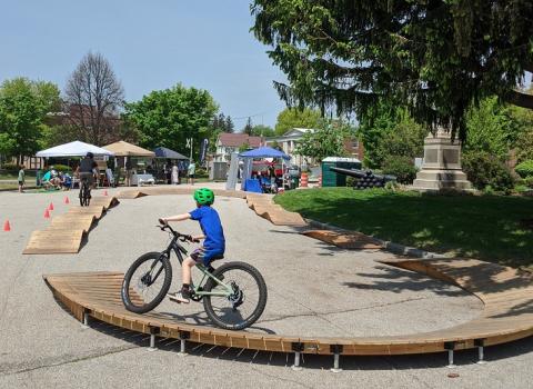 child riding a bicycle on a ramp course